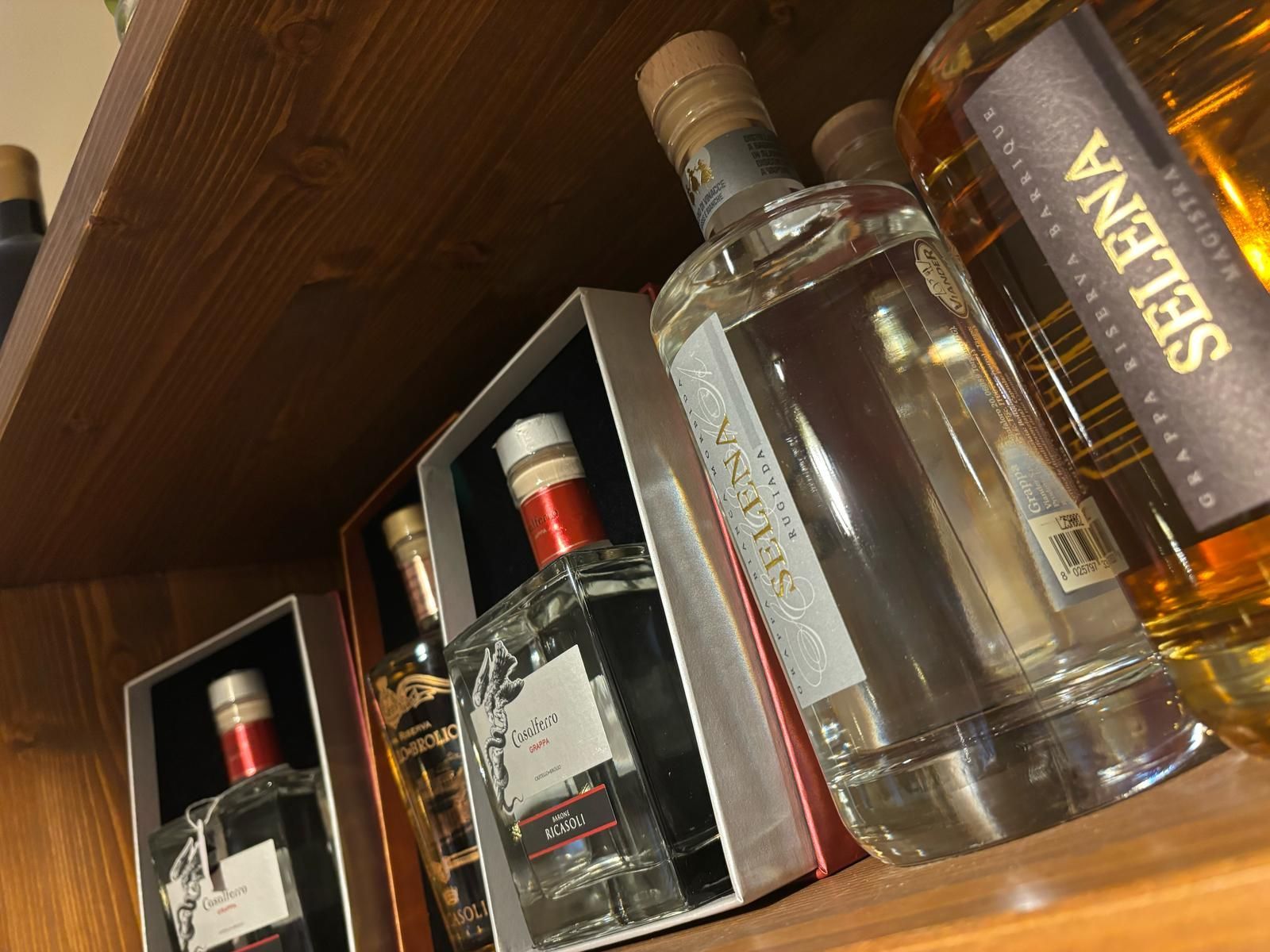 Uno scaffale con diverse bottiglie di alcolici tra cui Selena