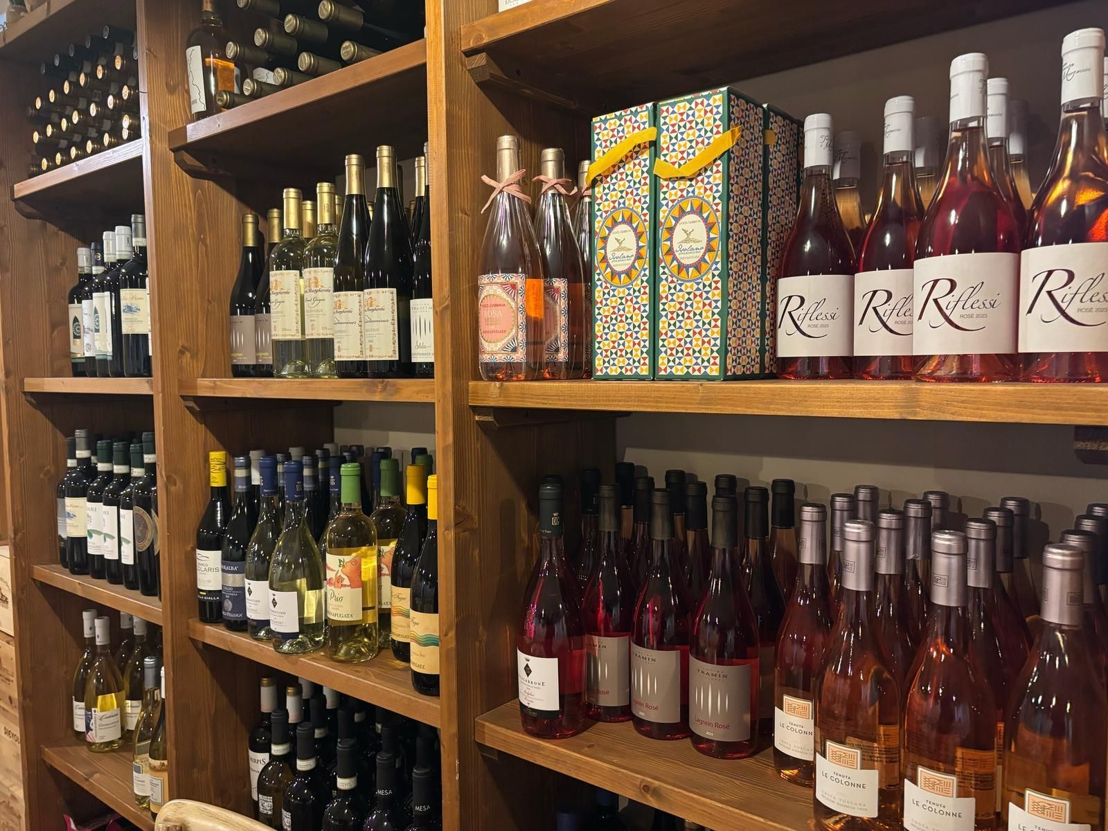 Una fila di scaffali pieni di bottiglie di vino e scatole.