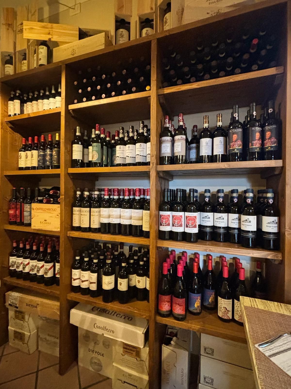 Scaffali pieni di bottiglie di vino, tra cui una con la scritta 