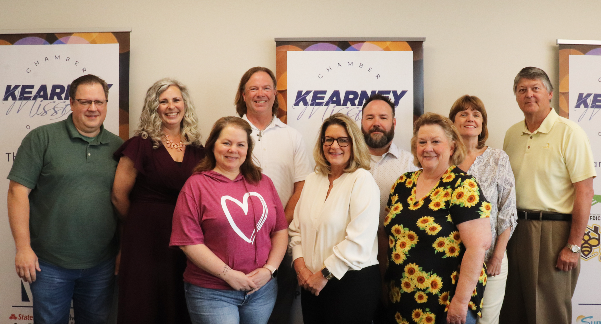 A group of nine people pose in front of 