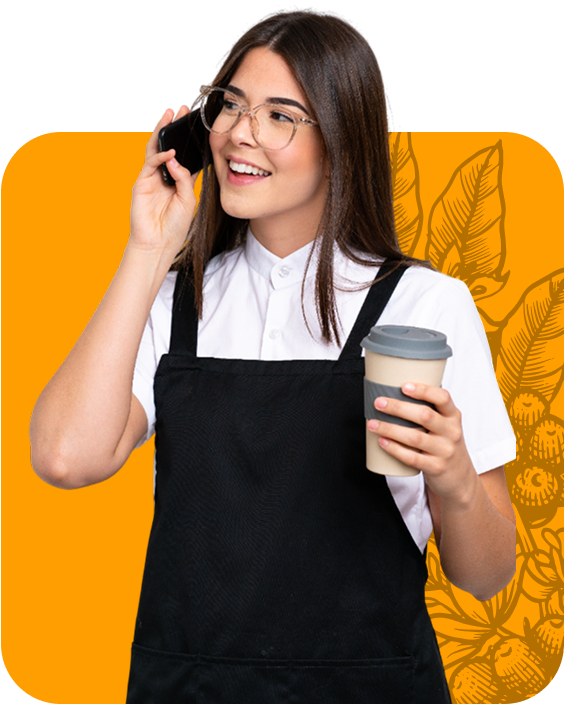 Woman in apron on phone, holding coffee cup, smiling.