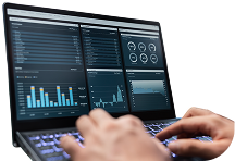 Hands typing on laptop displaying data charts and graphs.