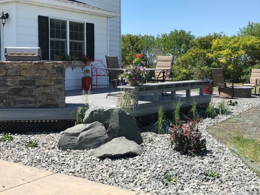 Deck with outdoor seating, grill, and rock landscaping.
