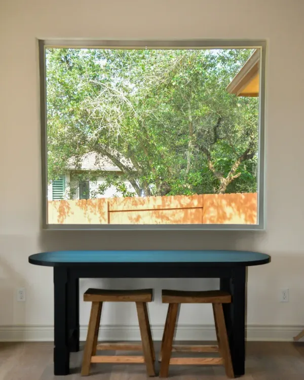 A man wearing a hard hat and goggles is standing in a room.
