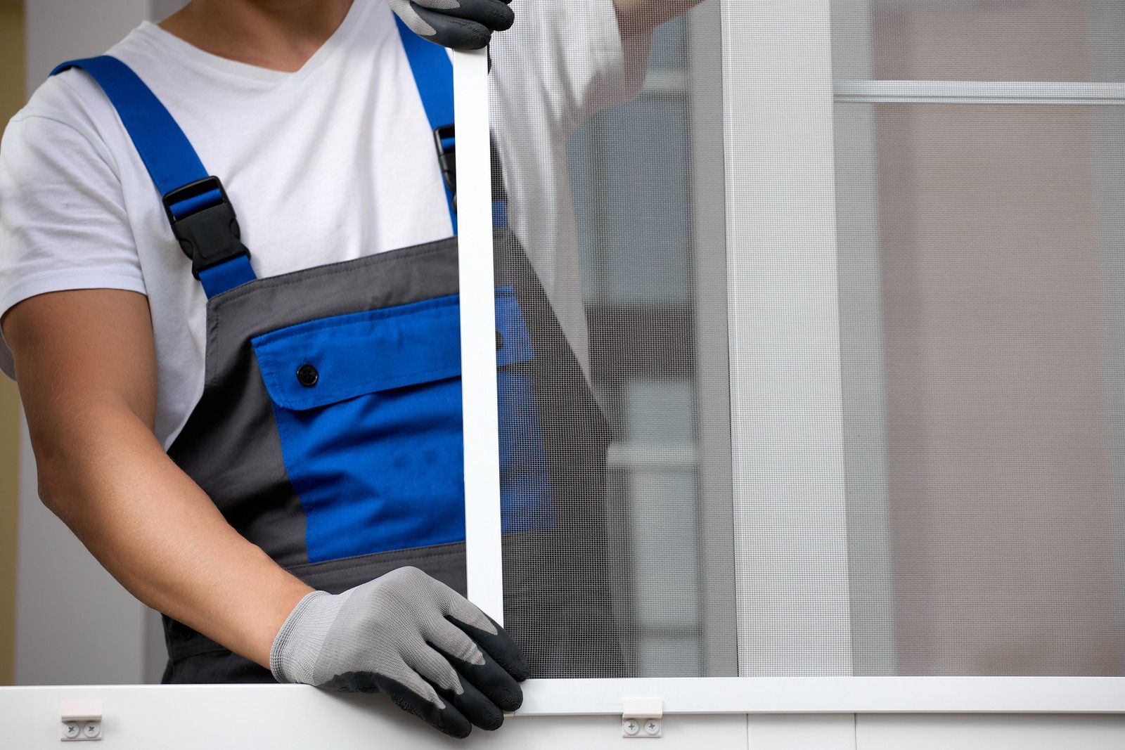 A man wearing a hard hat and goggles is standing in a room.