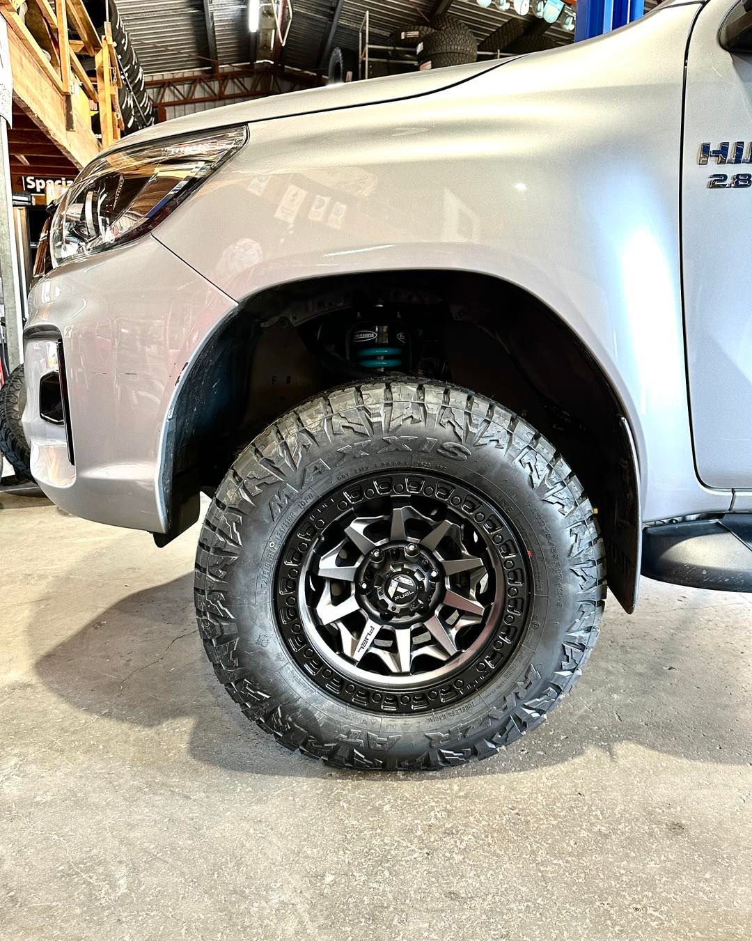 A silver truck with black wheels and tyres is parked in a garage — Capricorn Tyre & Mechanical in Yeppoon, QLD