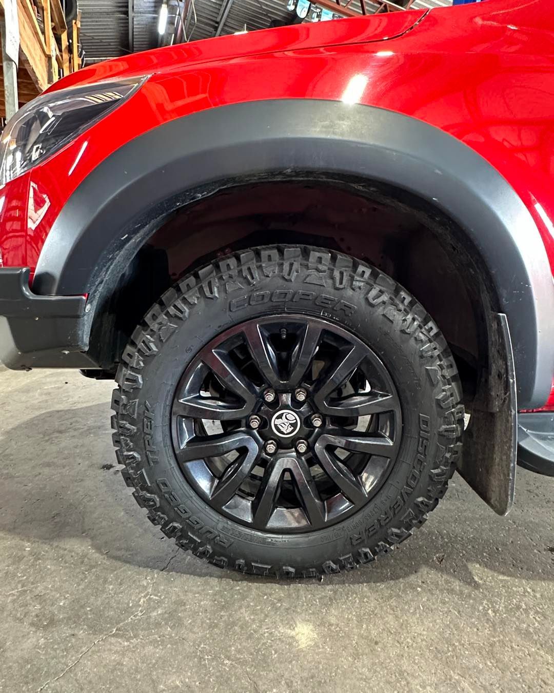 A red truck with black wheels and tyres is parked on the side of the road — Capricorn Tyre & Mechanical in Yeppoon, QLD