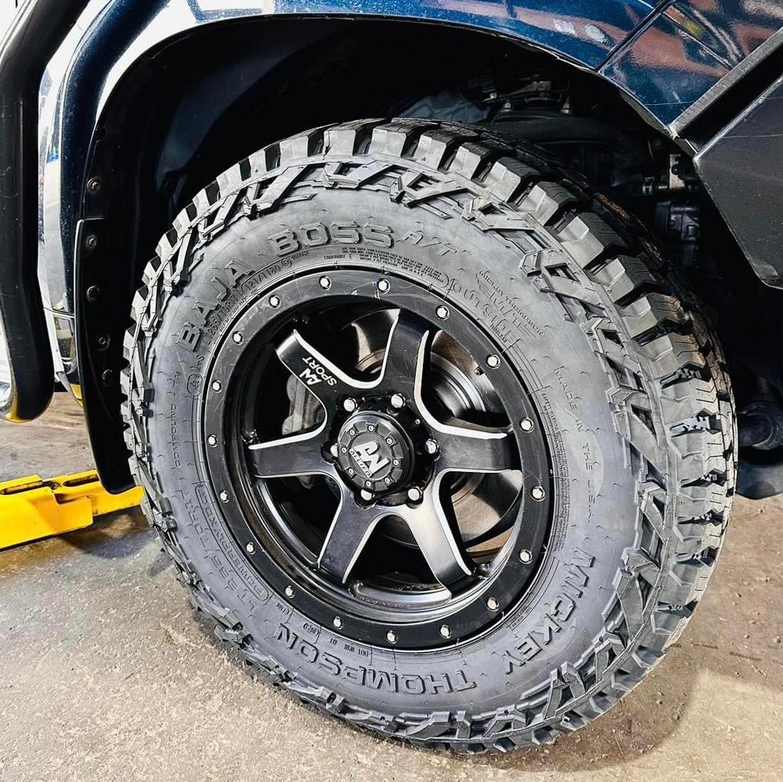 A close up of a tyre on a truck on a lift — Capricorn Tyre & Mechanical in Yeppoon, QLD