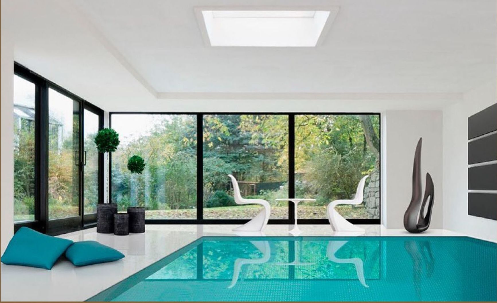 Una piscina in una stanza con molte finestre