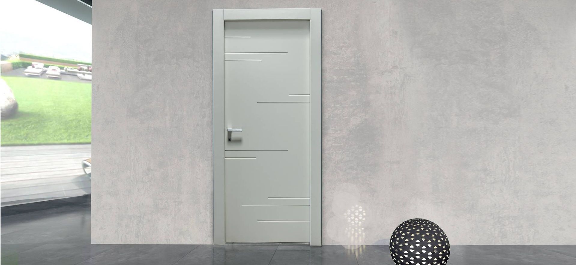 Una porta bianca è seduta in una stanza accanto a un muro grigio.