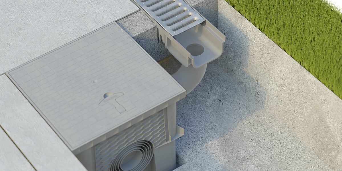 Un condizionatore d'aria è appoggiato su un pavimento di cemento accanto a uno scarico.