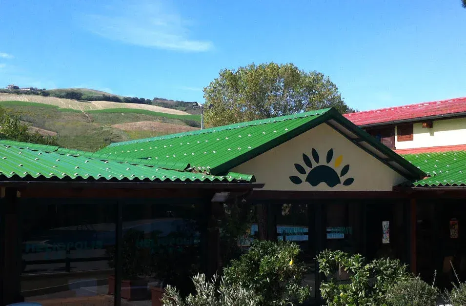 Una casa con il tetto verde e l'impronta di una zampa sopra