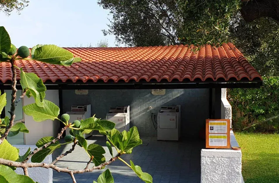 Un edificio con il tetto di tegole rosse e un cartello con su scritto 