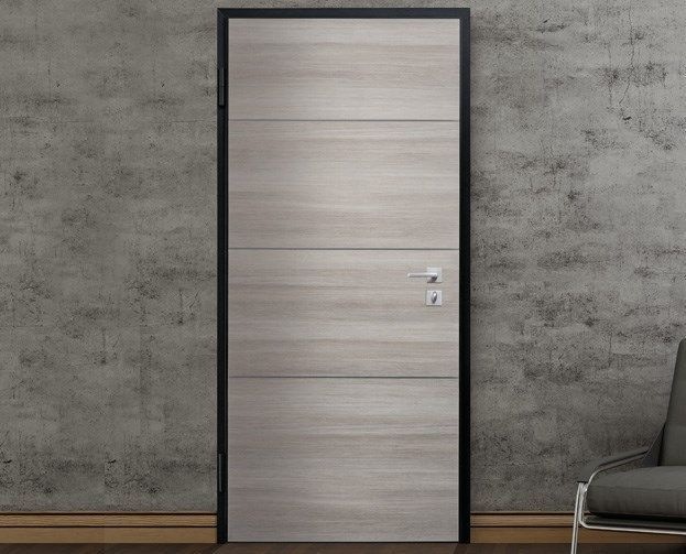 Una porta è contro un muro di cemento accanto a una sedia.