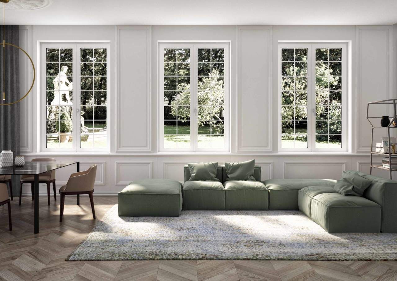 Un soggiorno con un divano componibile verde, un tavolo da pranzo e sedie.