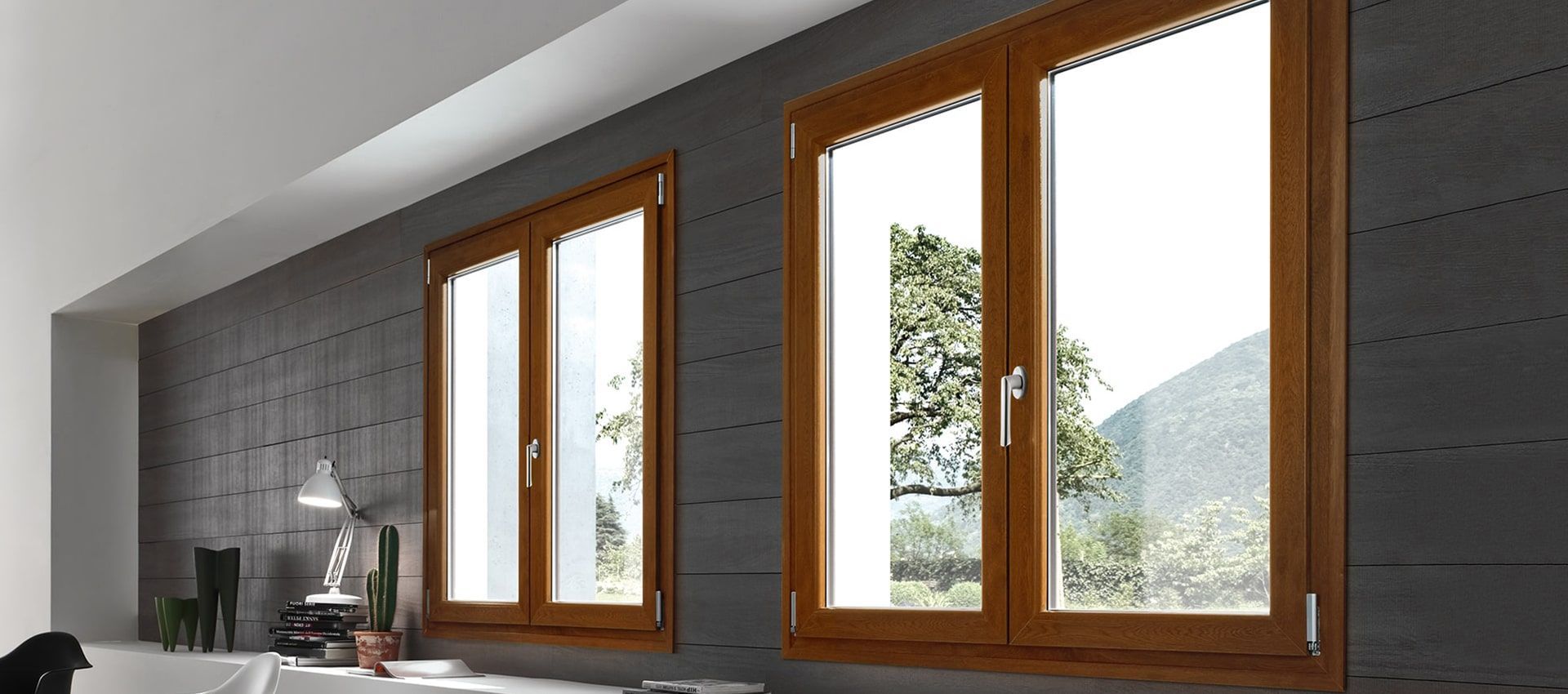 Una stanza con tre finestre e un muro grigio.