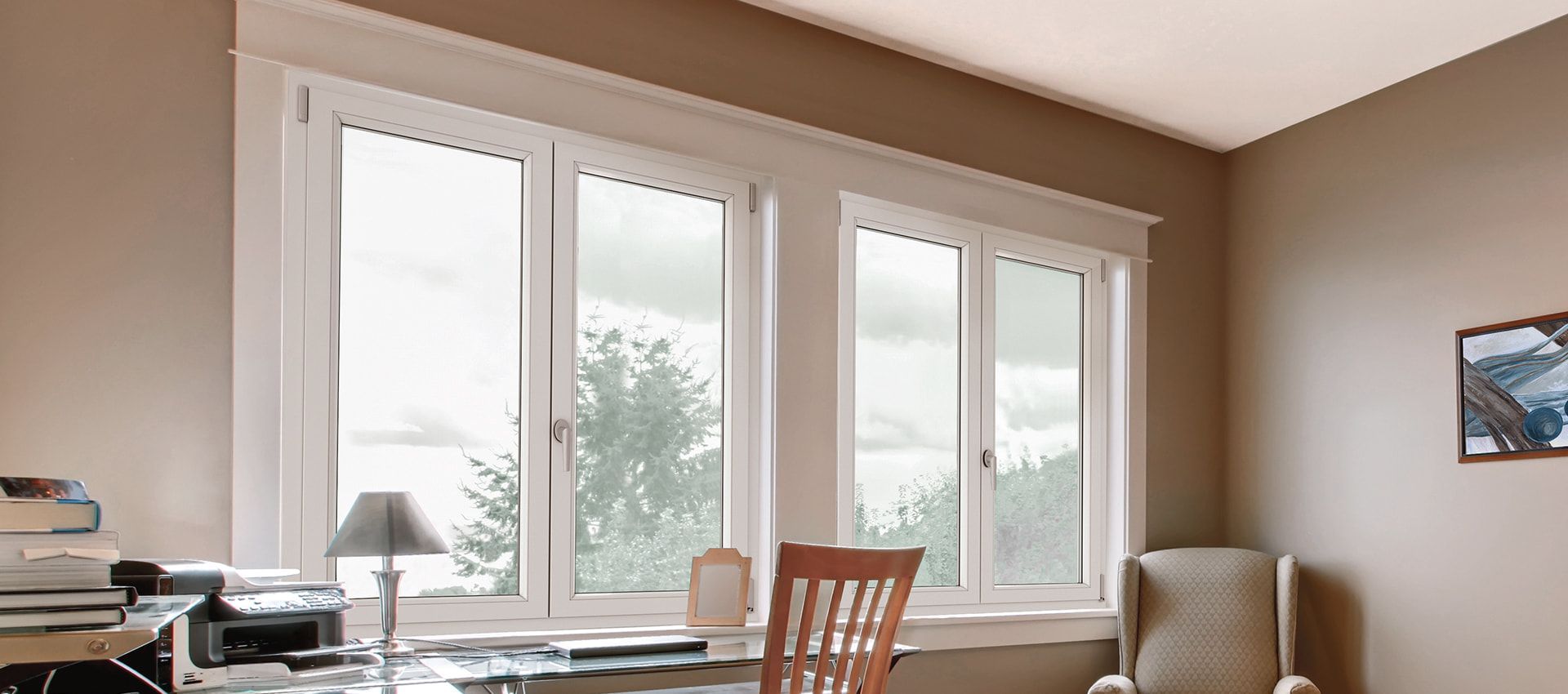 Una stanza con scrivania, sedia, lampada e una grande finestra.