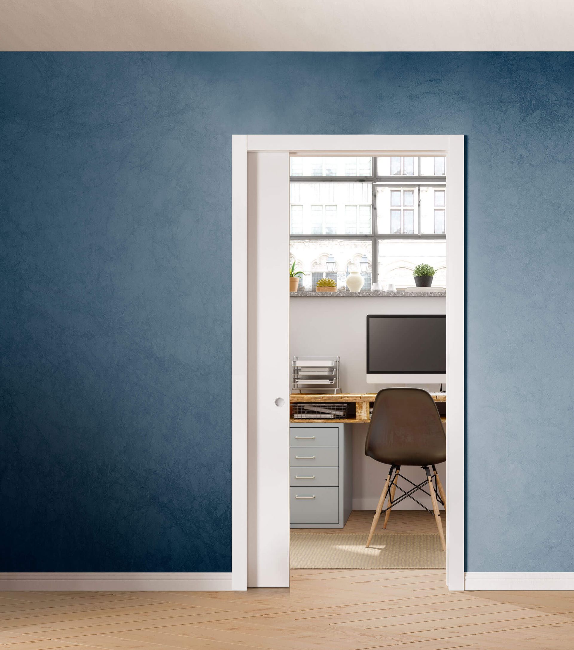 Una stanza con pareti blu e una porta scorrevole che conduce a una scrivania con sopra un computer.