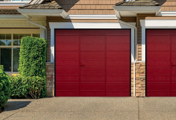 Una casa con due porte da garage rosse davanti