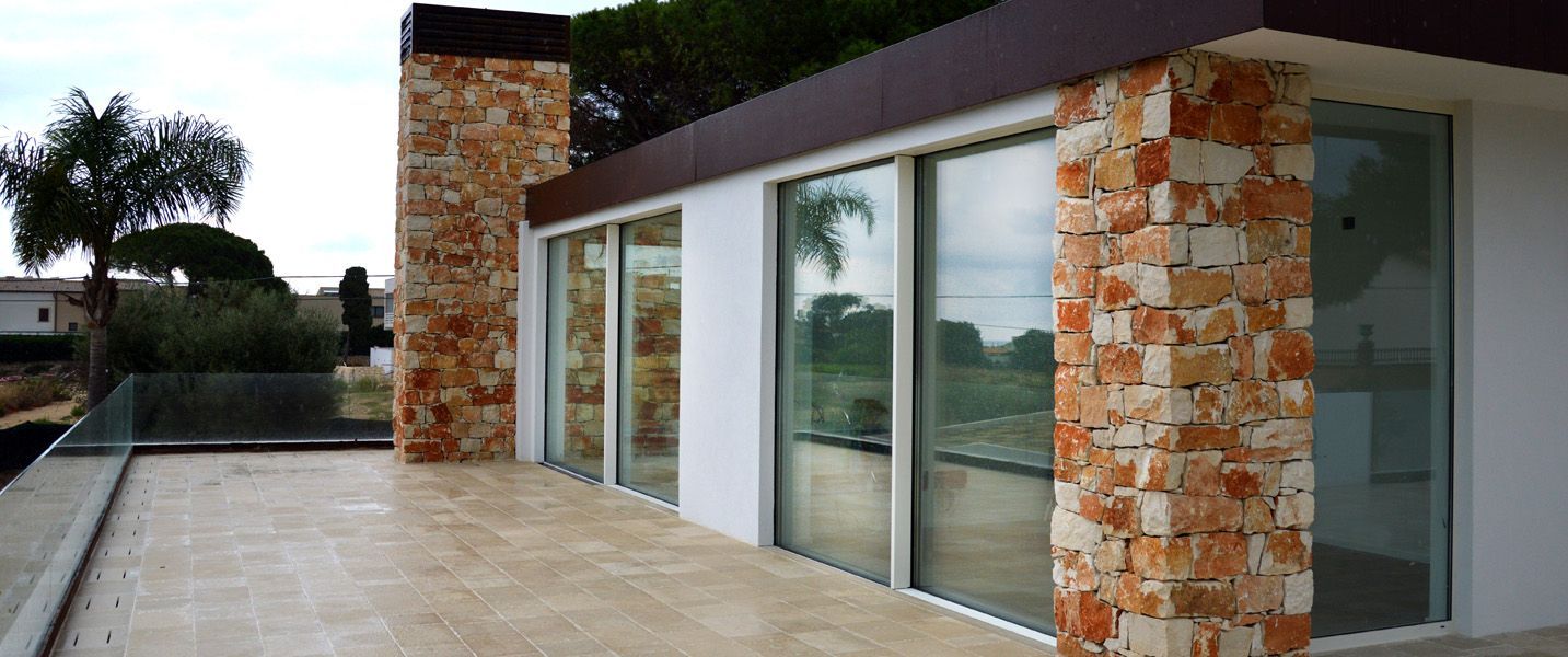 Una grande casa con molte finestre e un balcone.