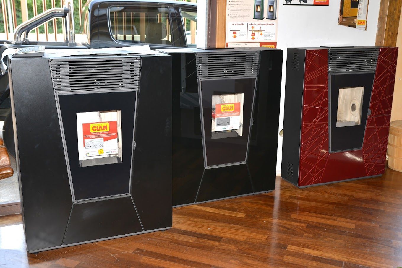 Tre scatole nere e rosse sono appoggiate su un pavimento di legno.