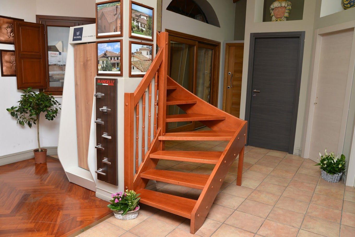 Una scala a chiocciola in legno si trova in un corridoio.