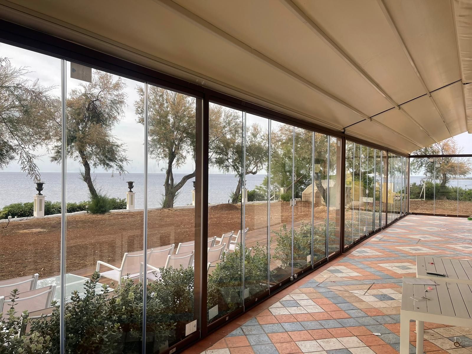 Un patio con tavoli e sedie e vista sull'oceano.