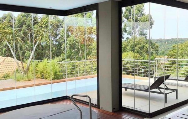 Dietro una parete di vetro con porte scorrevoli in vetro si trova una piscina.