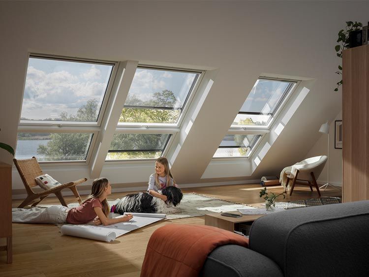 Due donne sono sdraiate sul pavimento in un soggiorno con molte finestre.