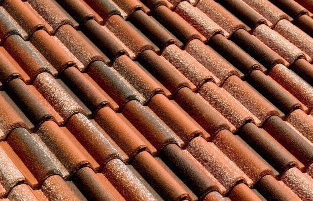 Un primo piano di una fila di tegole rosse su un tetto