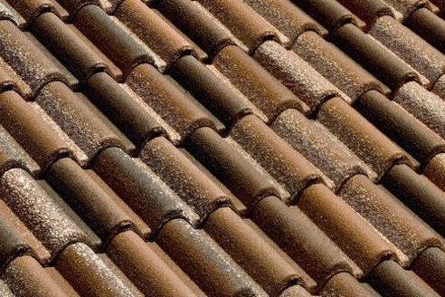 Un primo piano di una fila di tegole marroni su un tetto.