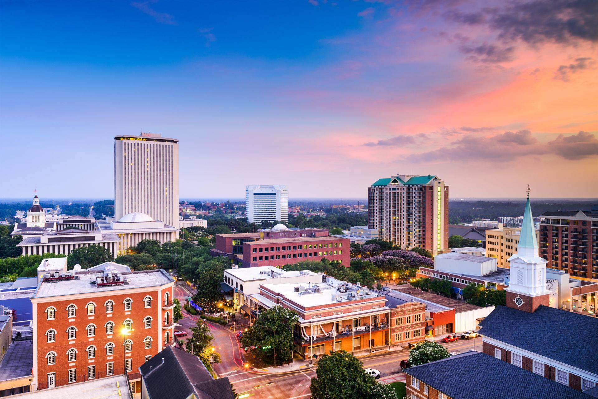 an aerial view of tallahassee florida city with a sunset in the background