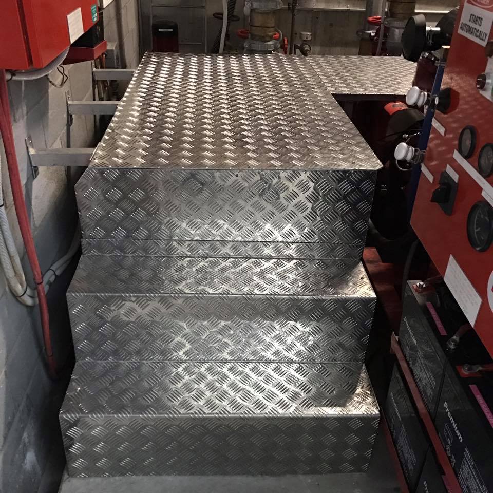 Aluminum diamond plate steps and platform in a room.