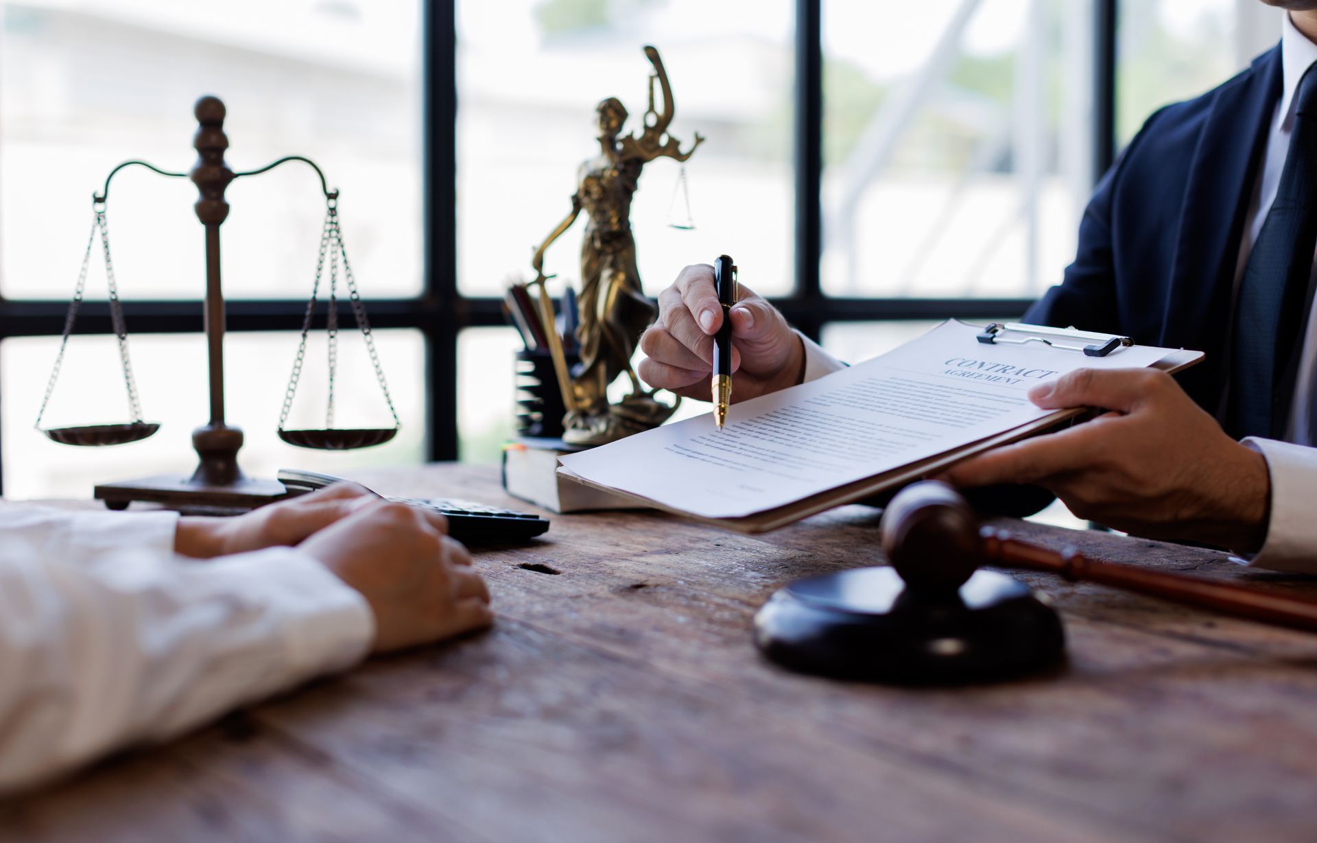 A consultation between a personal injury attorney and a client at a desk with a wooden gavel.