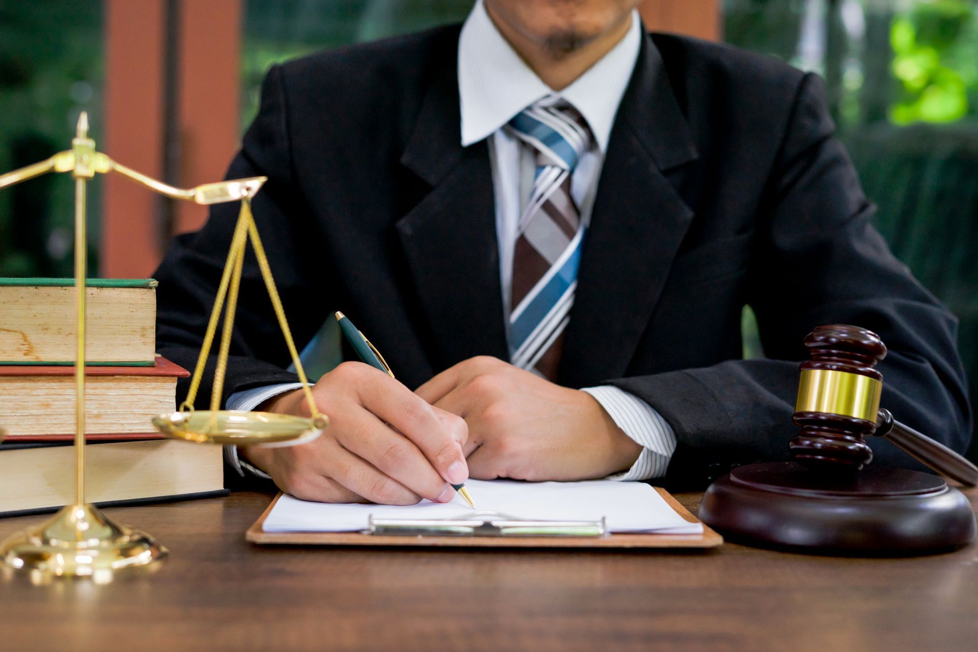 Lawyer at wooden desk with gavel and sound block symbolizing justice.