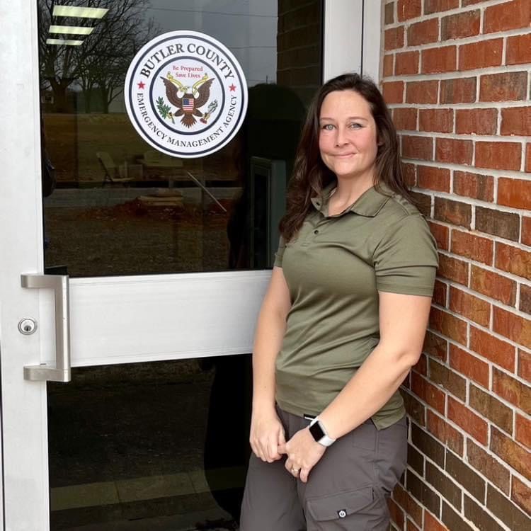 Rosie Till stands in front of a door that says butter county emergency management agency