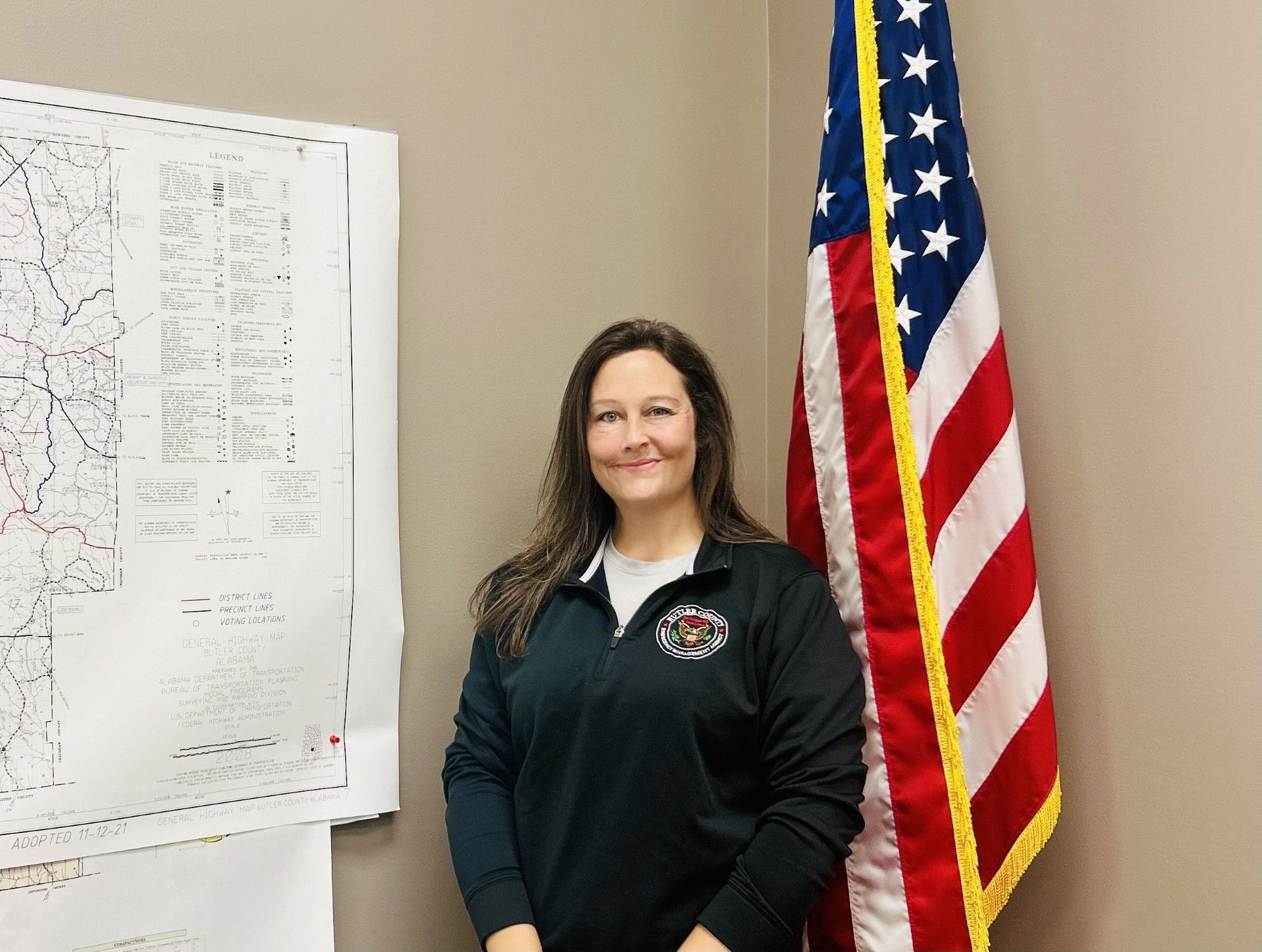 Rosie Till stands in front of a door that says butter county emergency management agency