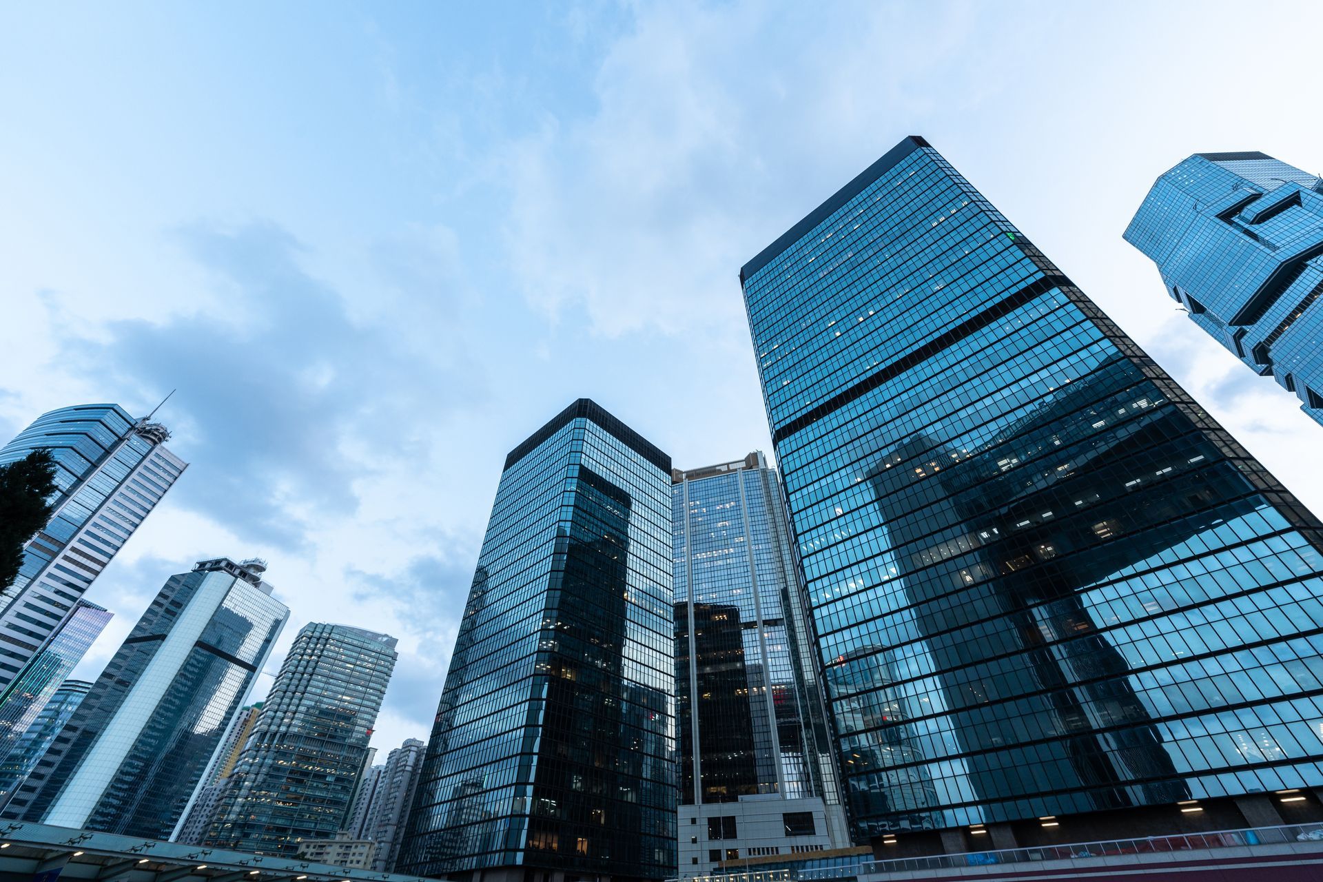 Skyscrapers with glass facades reflect a cloudy sky