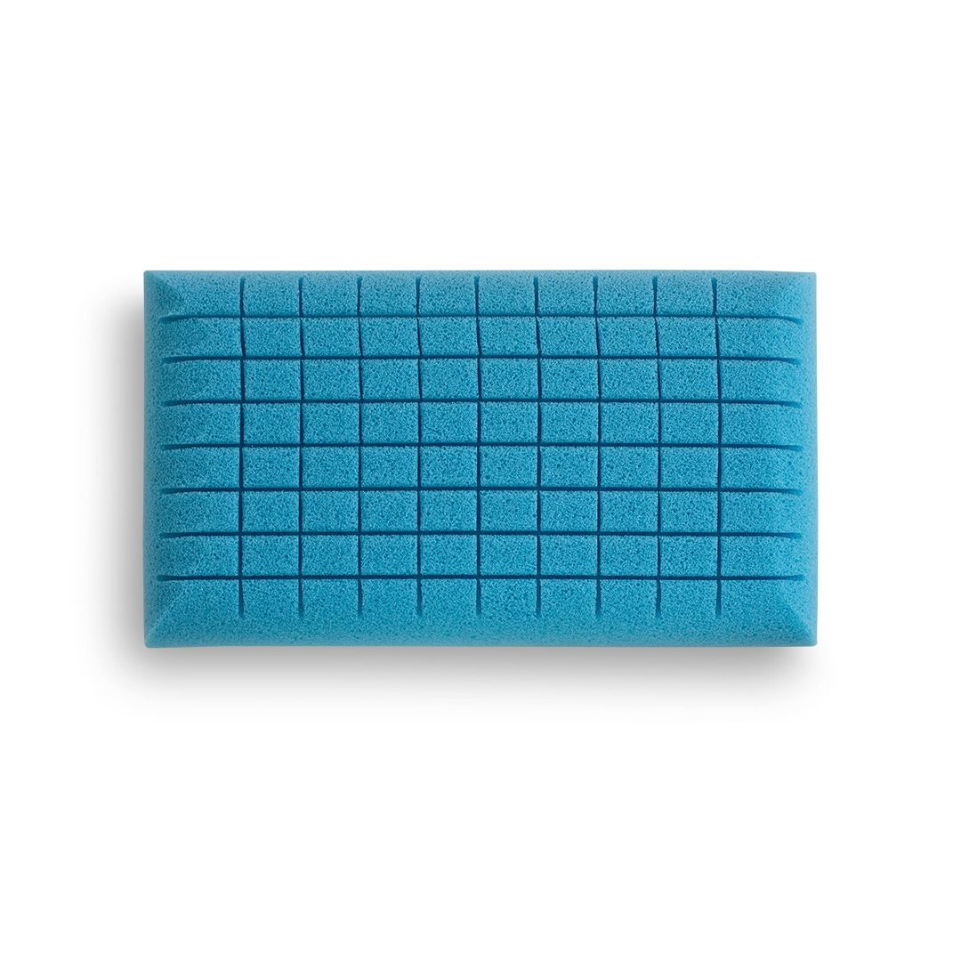 Una spugna rettangolare blu con una superficie superiore caratterizzata da una trama a griglia di scanalature.