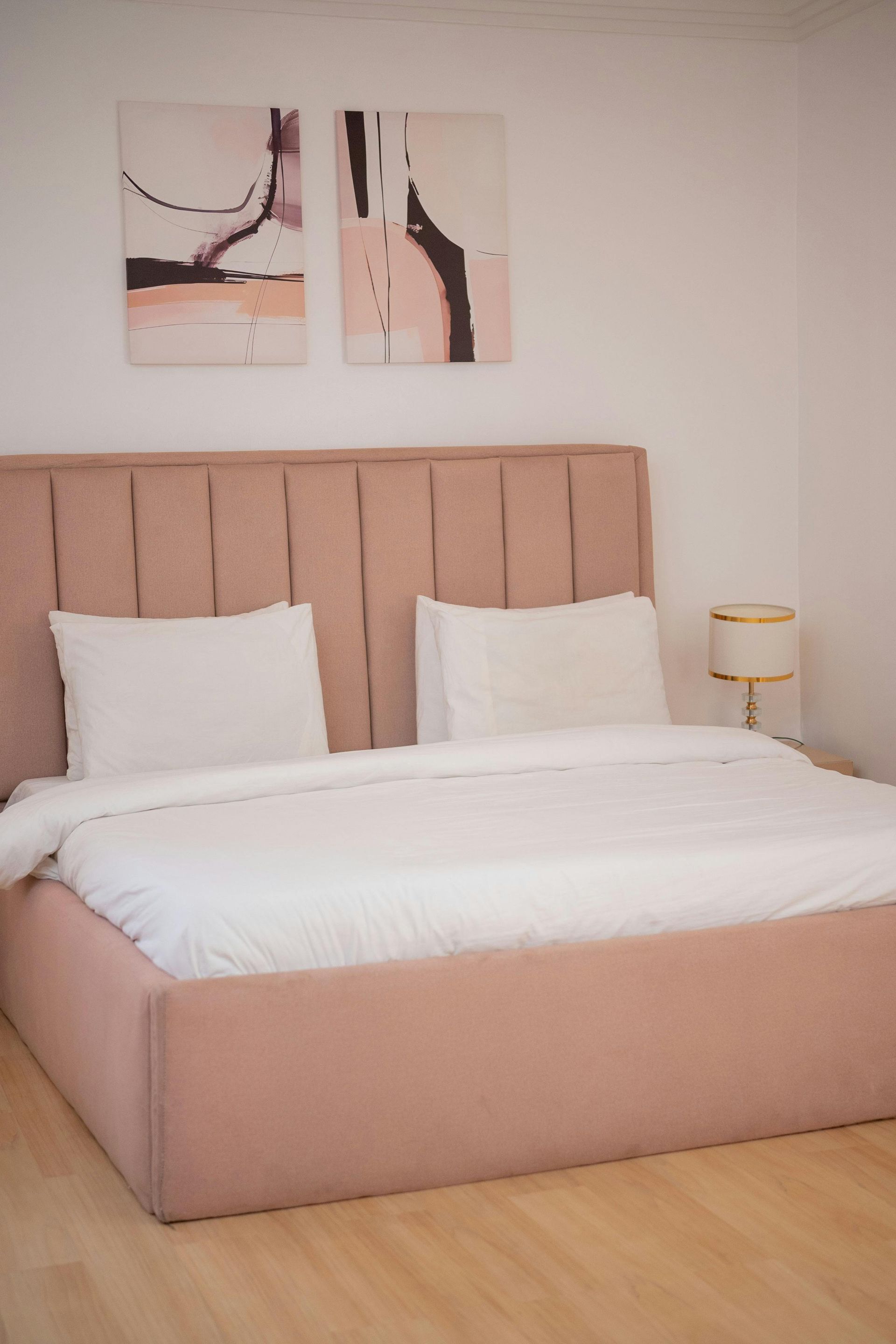 In uno showroom sono esposti due moderni letti imbottiti, uno verde e l'altro blu con un plaid promozionale rosso.