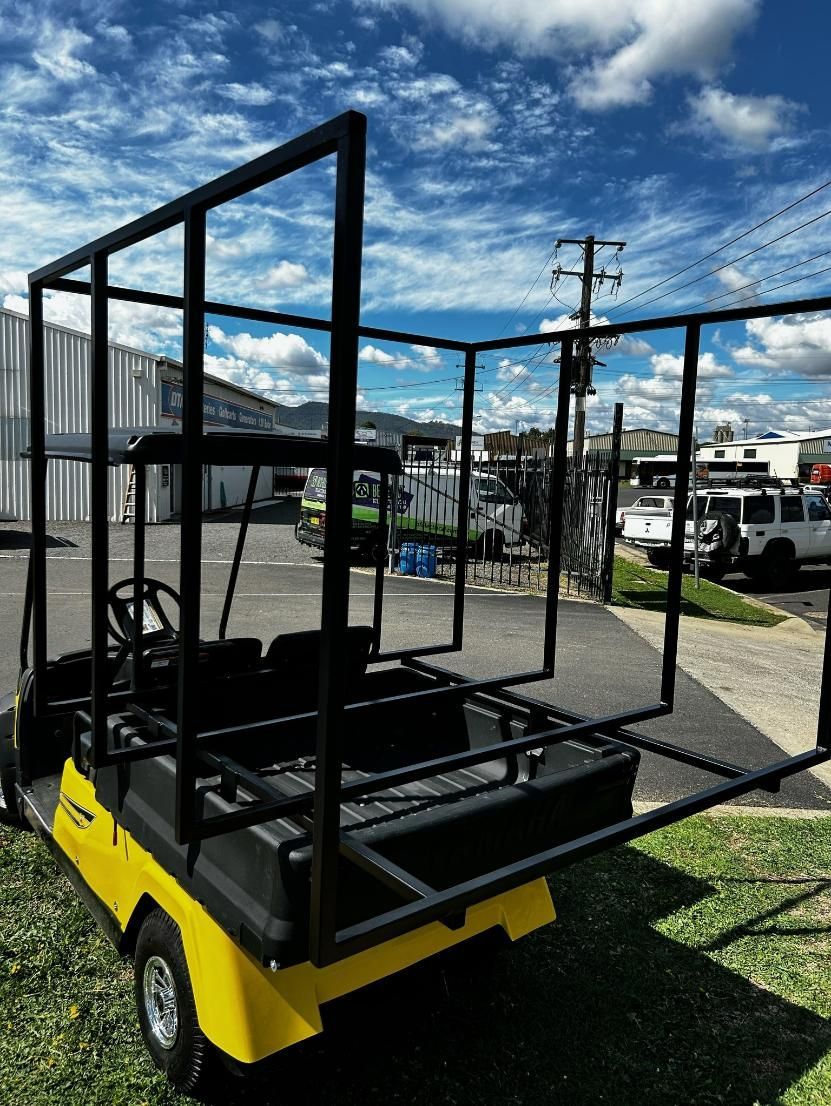 A Yellow Golf Cart with A Black Frame Is Parked in The Grass — DTM Tamworth in Armidale, NSW