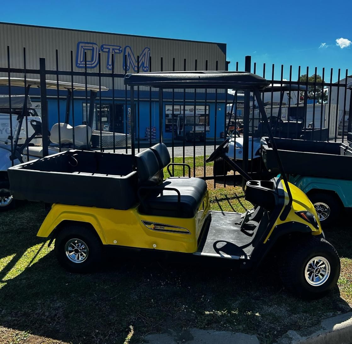 A Yellow Golf Cart Is Parked in Front of A Building that Says Dtm — DTM Tamworth in Gunnedah, NSW