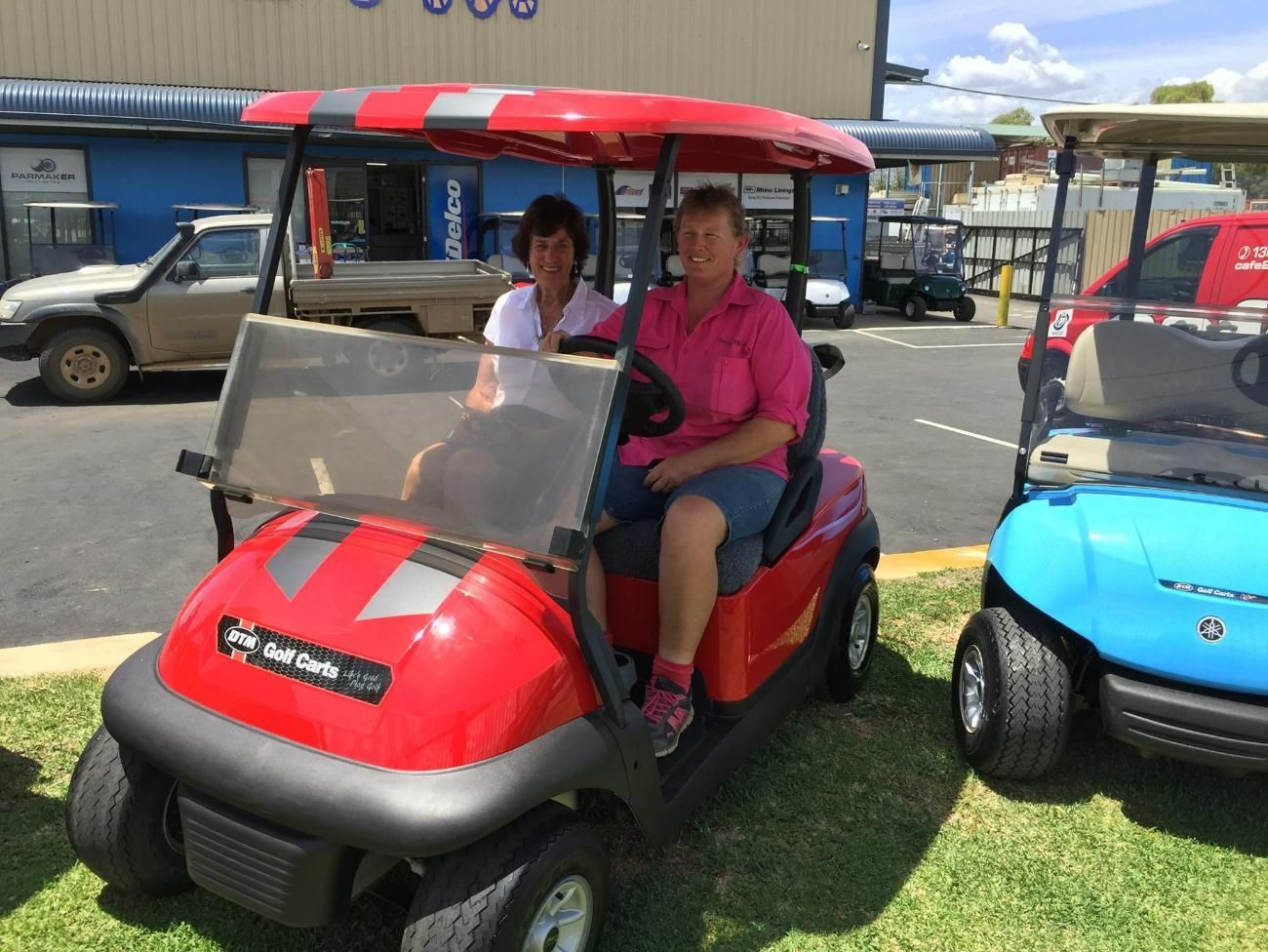 Two Persons On A Red Golf Cart — DTM Tamworth in Tamworth, NSW