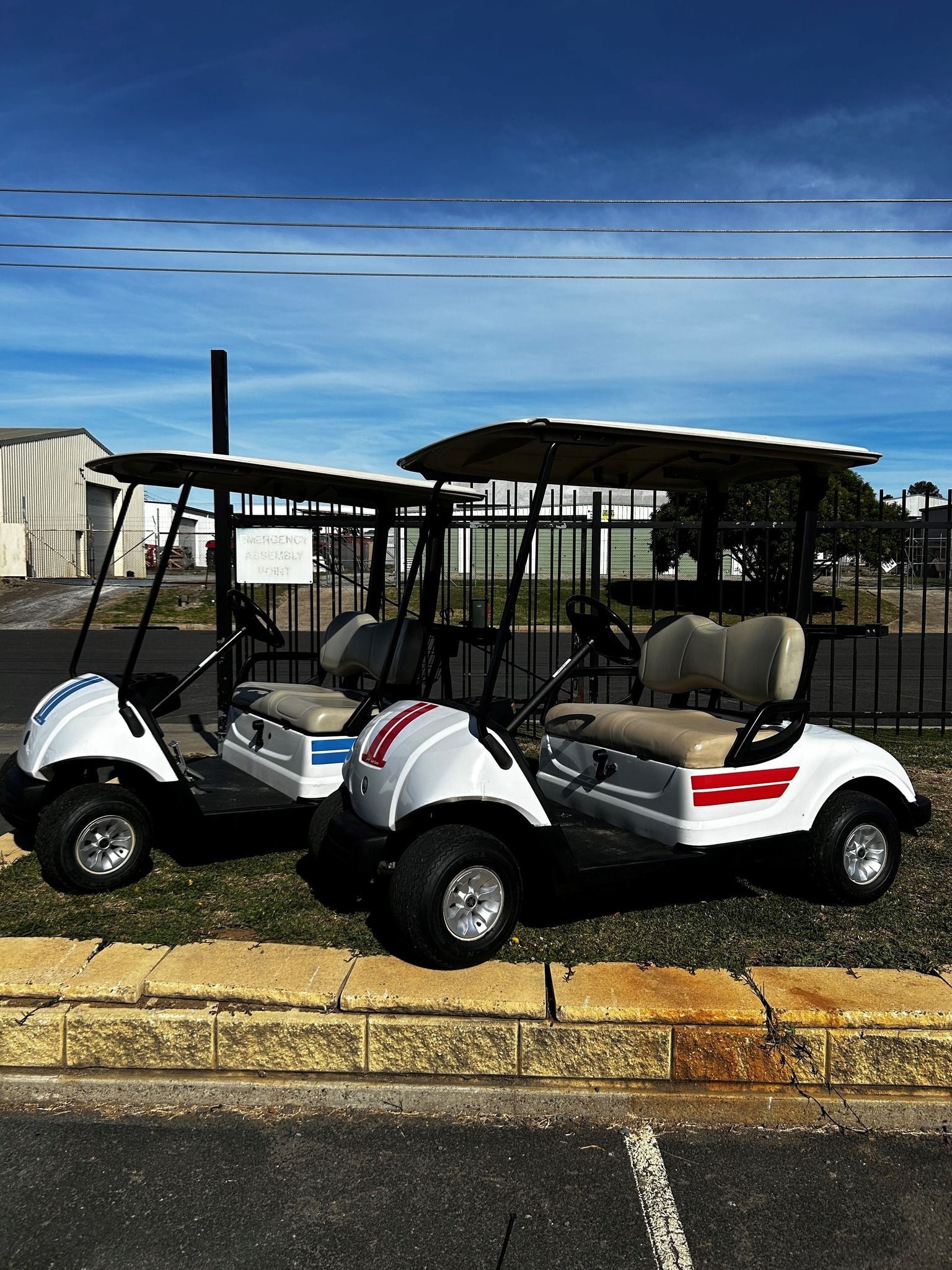 Two White Golf Carts Parked Outside