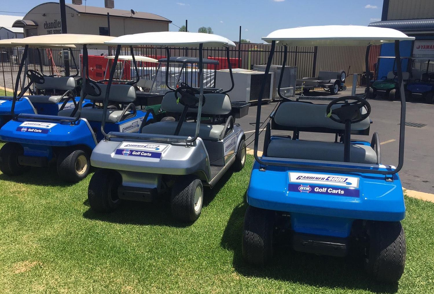 Three Golf Carts Parked On Grass