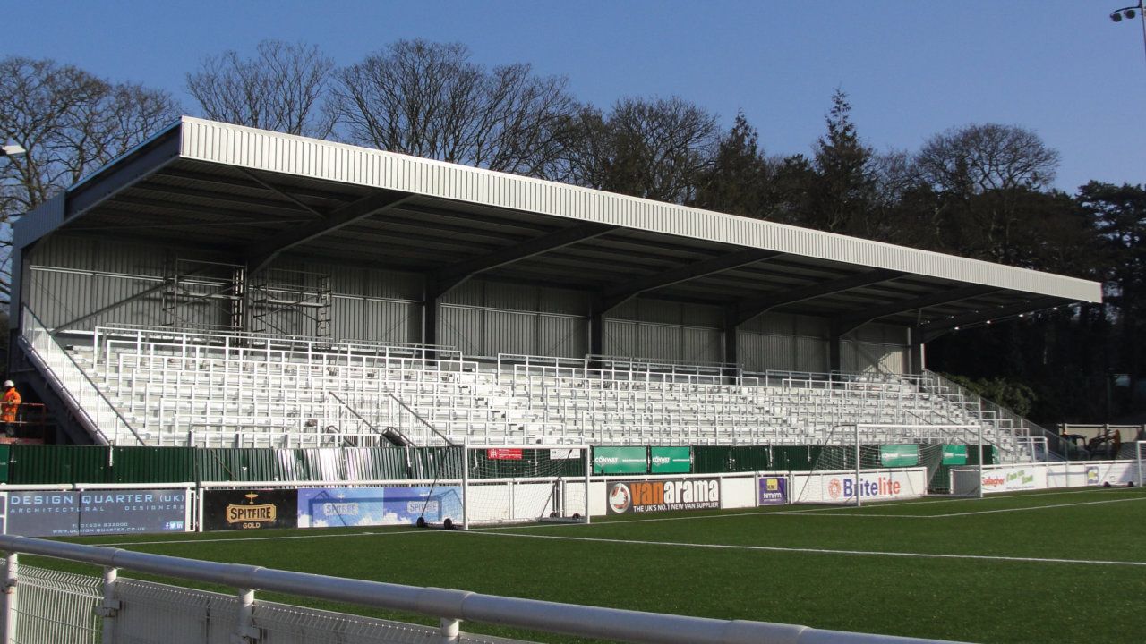 A soccer field with a stadium in the background