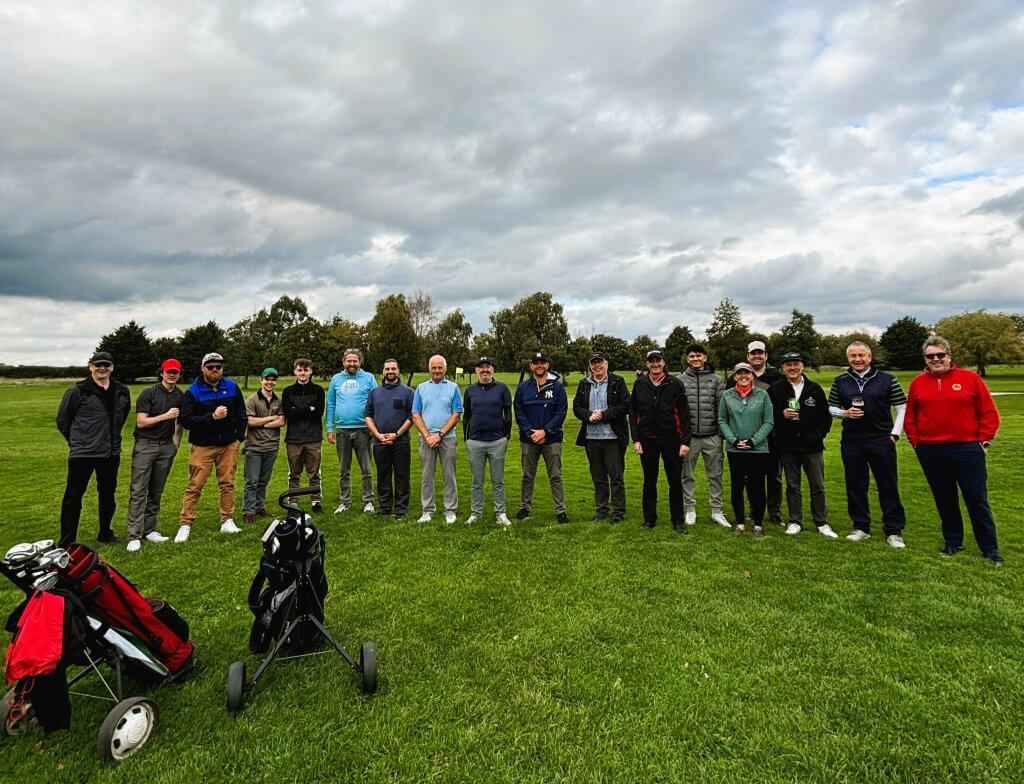 A group of people are posing for a picture on a golf course.