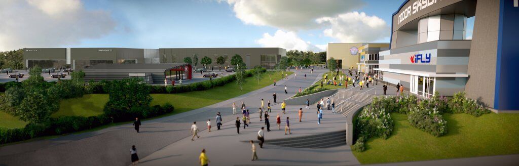 A group of people are walking down a sidewalk in front of a large  Reidsteel building.