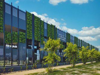 A large  Reidsteel building with a lot of windows and trees in front of it.