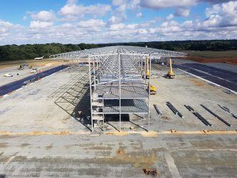 An aerial view of a  Reidsteel building under construction on a runway.